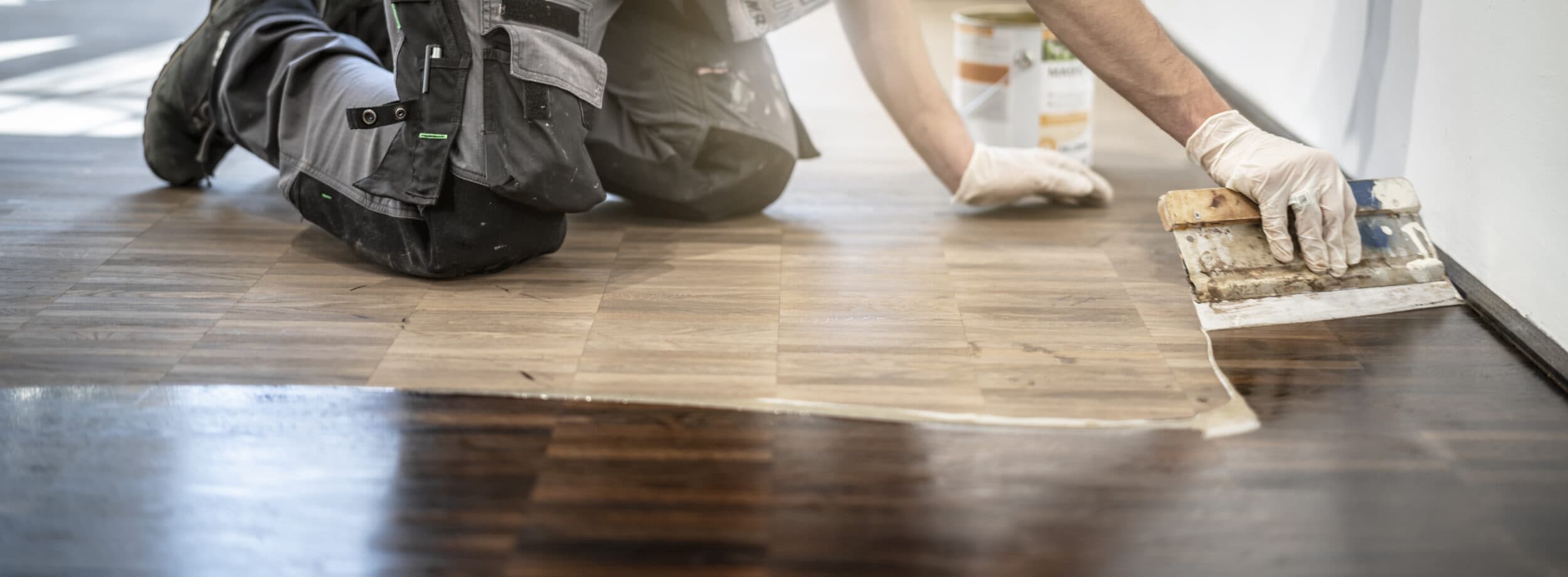 Zwei Handwerker beim Verlegen eines Holzbodens